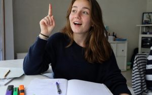 Nastolatka podnosi palec do góry, jakby właśnie wpadła na pomysł.