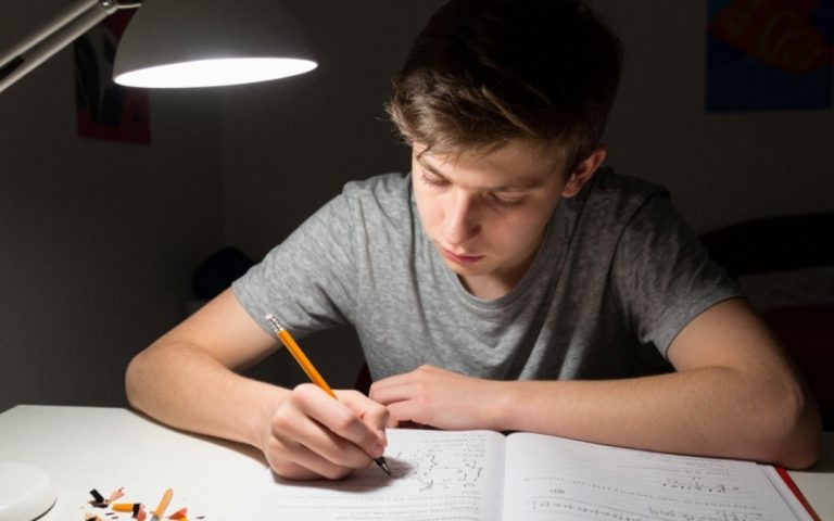 Nastolatek rozwiązuje logarytmy nocą przy lampce