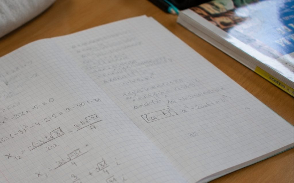 Zbliżenie na zeszyt z notatkami z matematyki.