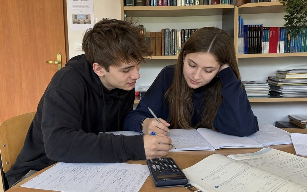 Spokojny kącik do nauki w bibliotece z zeszytami i książkami, przygotowany do pracy nad matematyką.